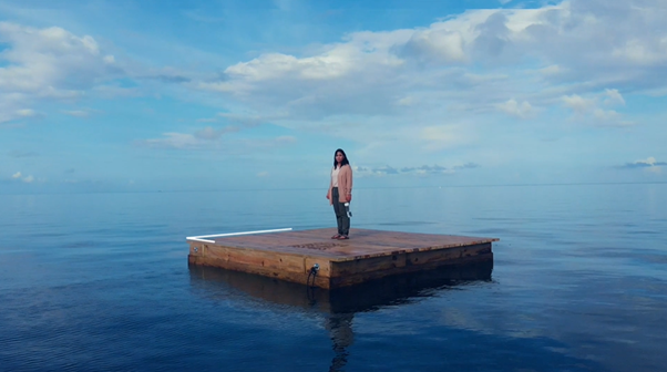 Image of woman standing alone on a raft at sea